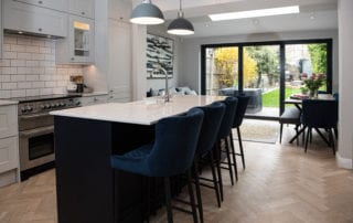 Open plan kitchen with blue velvet bar stools