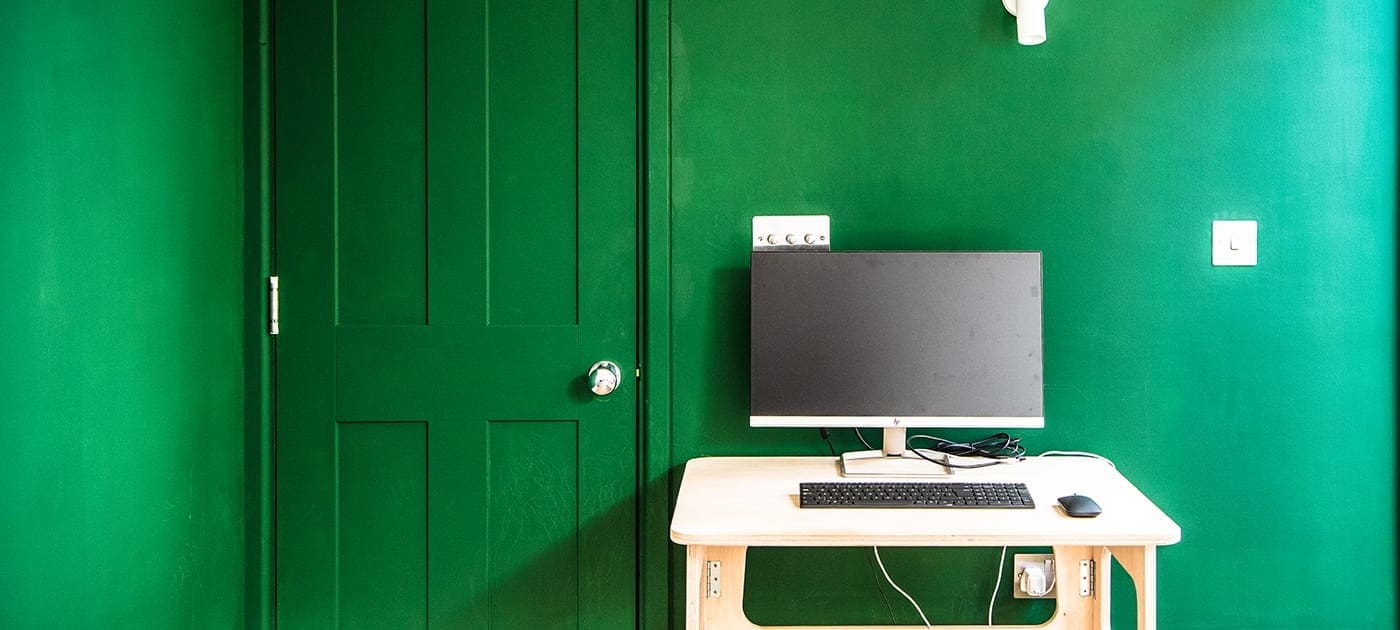 Desk against green and white wall