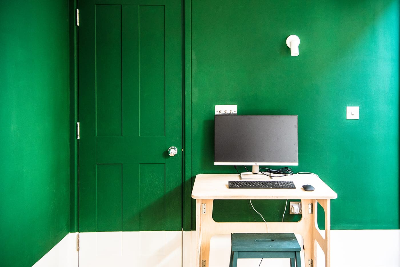 Desk against green and white wall